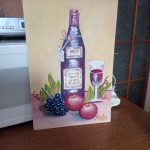 przedstawia rysunke, na którym znajuje się butelka, kieliszek oraz jabłka i winogrono