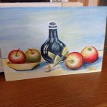 przedstawia rysunek, na którym widać na środku kafakę a z prawej i lewej strony po dwa jabłka