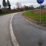 Fragment drogi asfaltowej oraz wyznaczona ścieżka rowerowa.